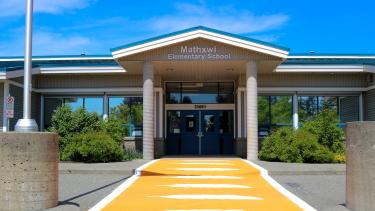 Crosswalk Unveiling 2023 Mathxwí Elementary Exterior Image with orange crosswalk in front