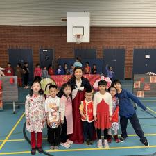 Group of students dressed up for Lunar New Year pose with Vice Prinicpal